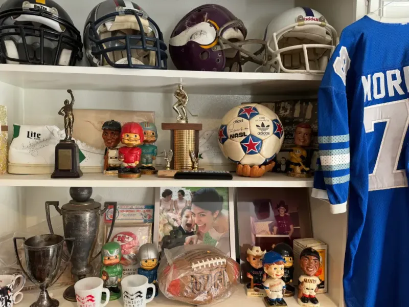 Sell vintage sports memorabilia in San Antonio Tx — a hand pressed flat against newly completed work blending into its surroundings